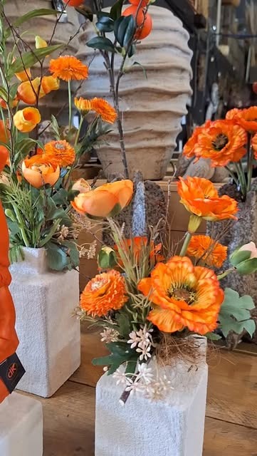 Oranje bloemen in witte vazen